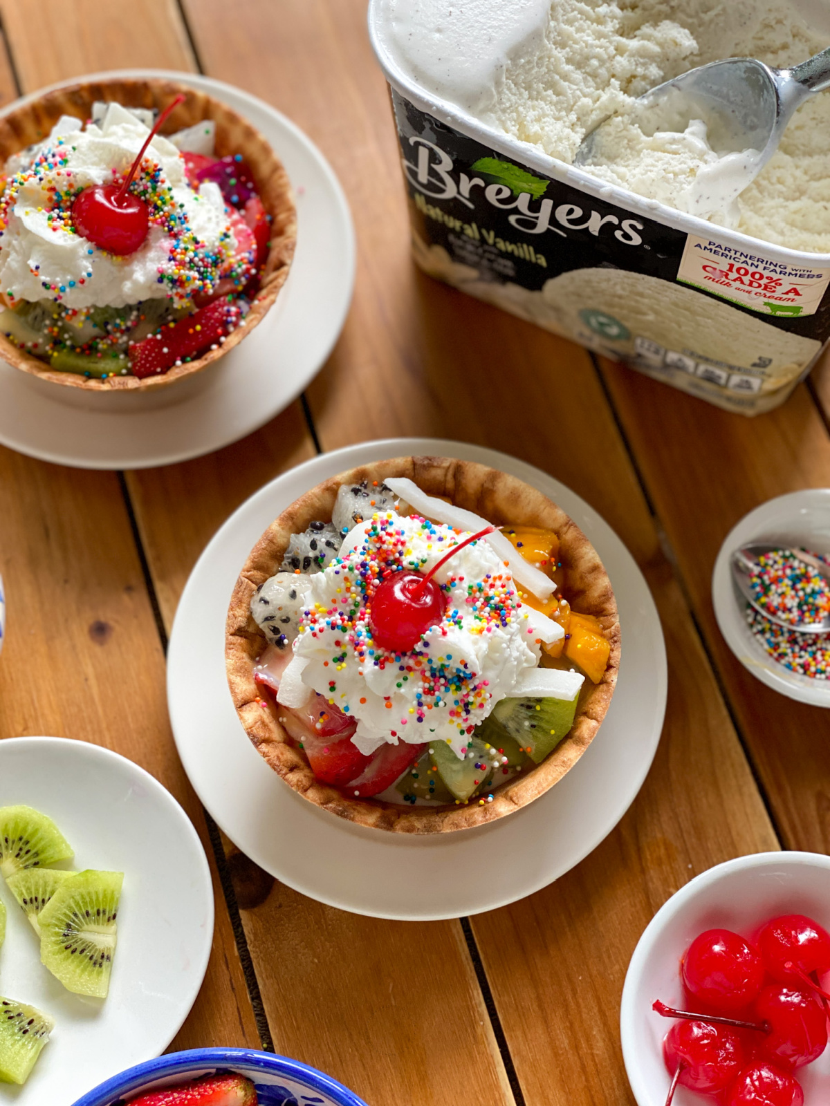 two cups of ice cream with fruits and whipped cream are the perfect ending for a homestyle menu