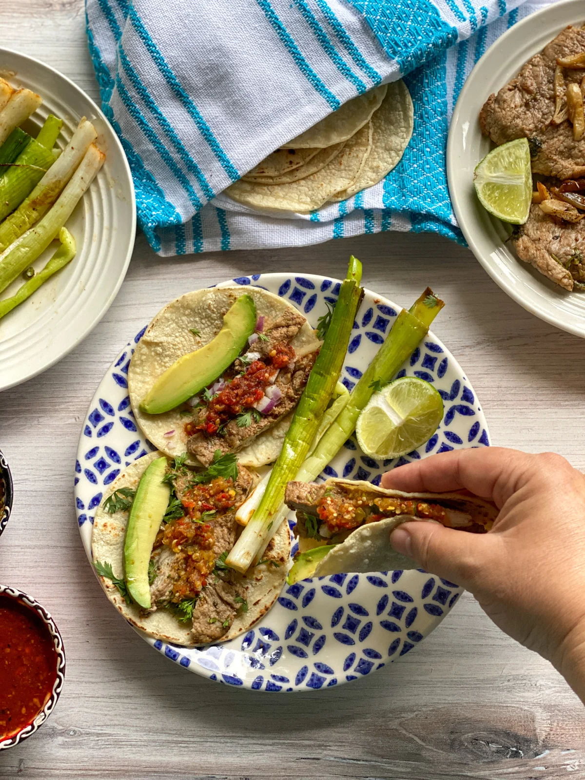 a hand holding a taco with meat and salsa