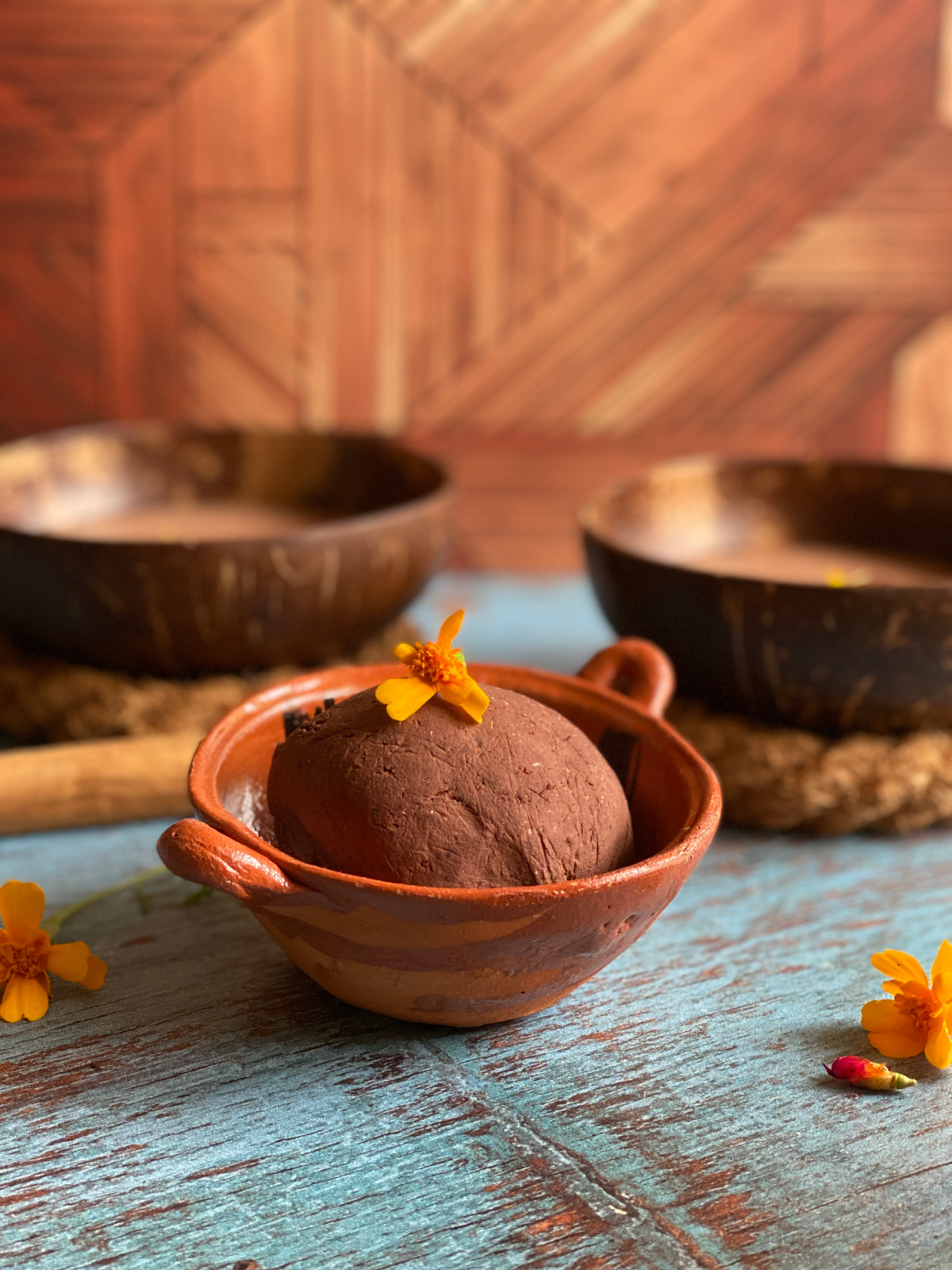 una bola de masa harina mezclada con cacao tostado y con una caléndula encima