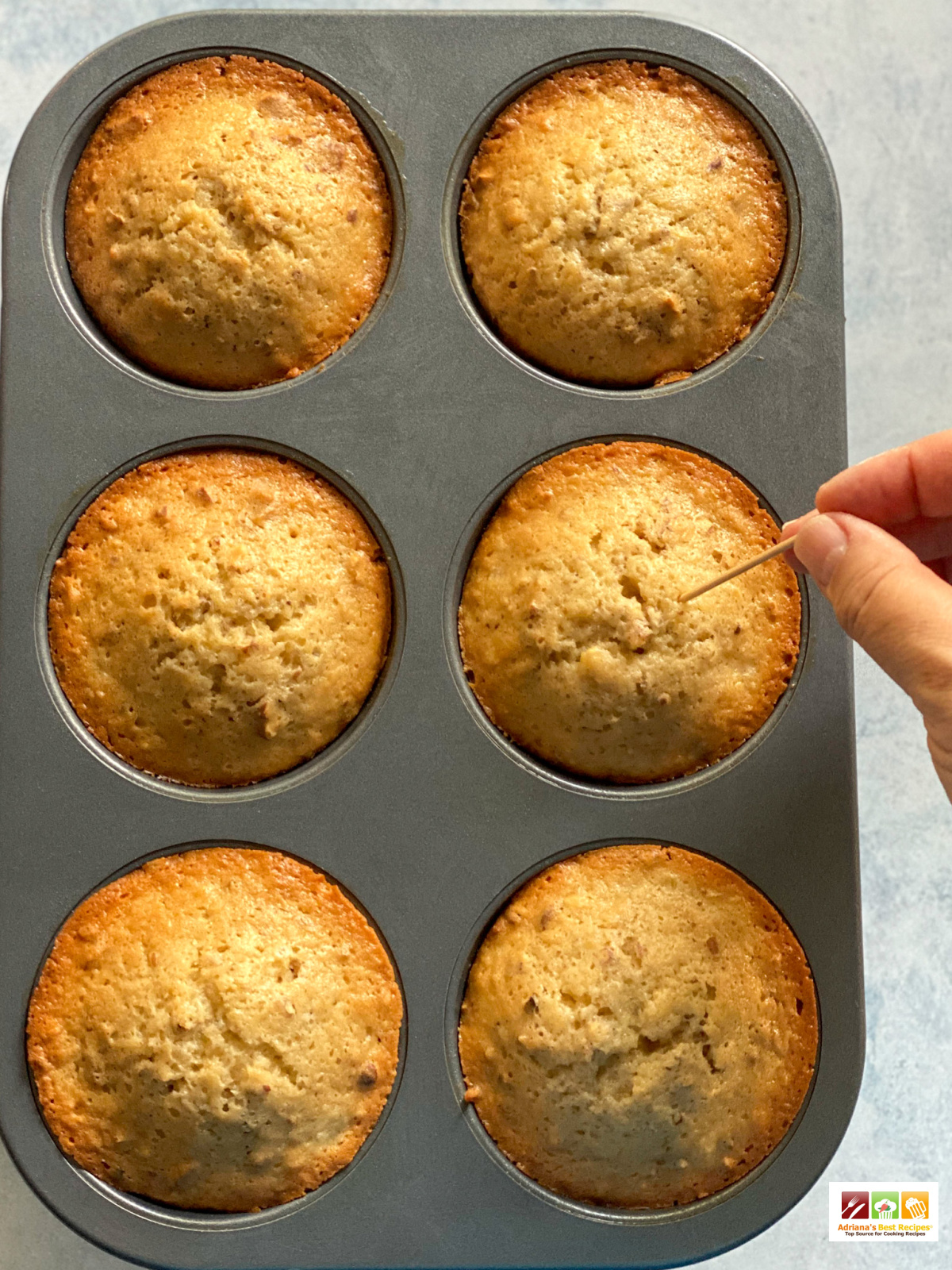 Pinching the cupcakes with a toothpick to verify doneness