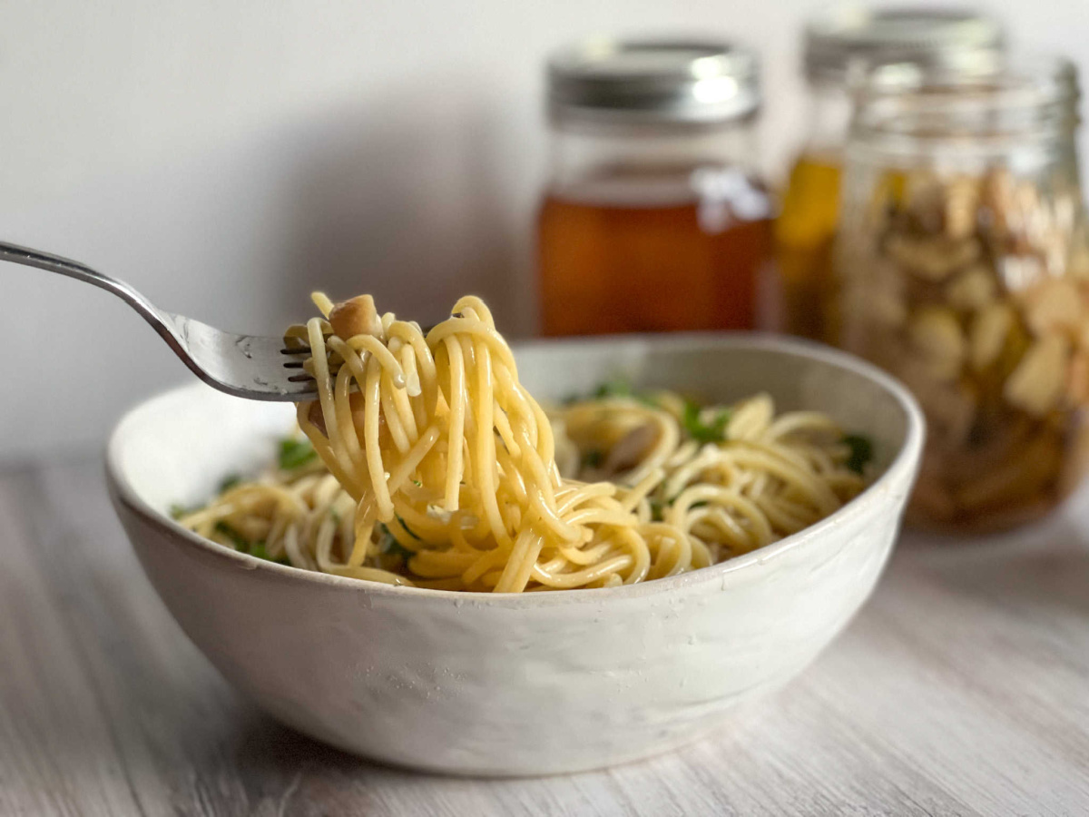 a fork full of pasta with garlic confit and garlic oil