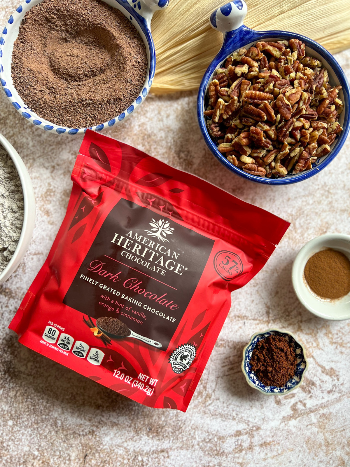 A bag of chocolate and bowls with pecans and spices