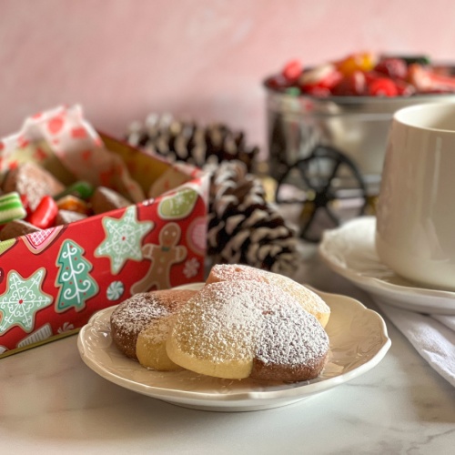 a plate with cookies dusted with powdered sugar