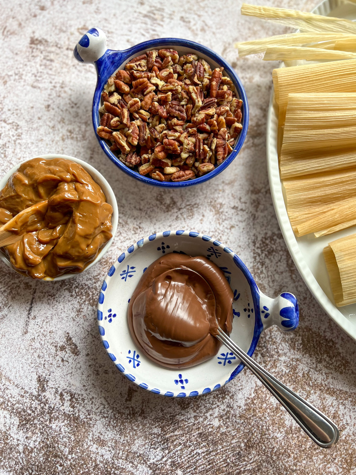three bowls with pecans dulce de leche and hazelnut spread