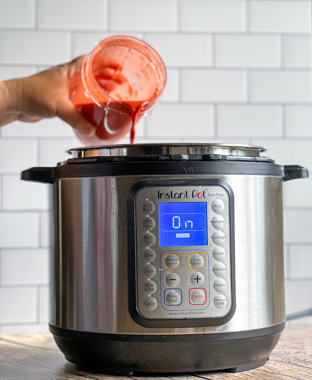 Pouring the achiote sauce into the instant pot