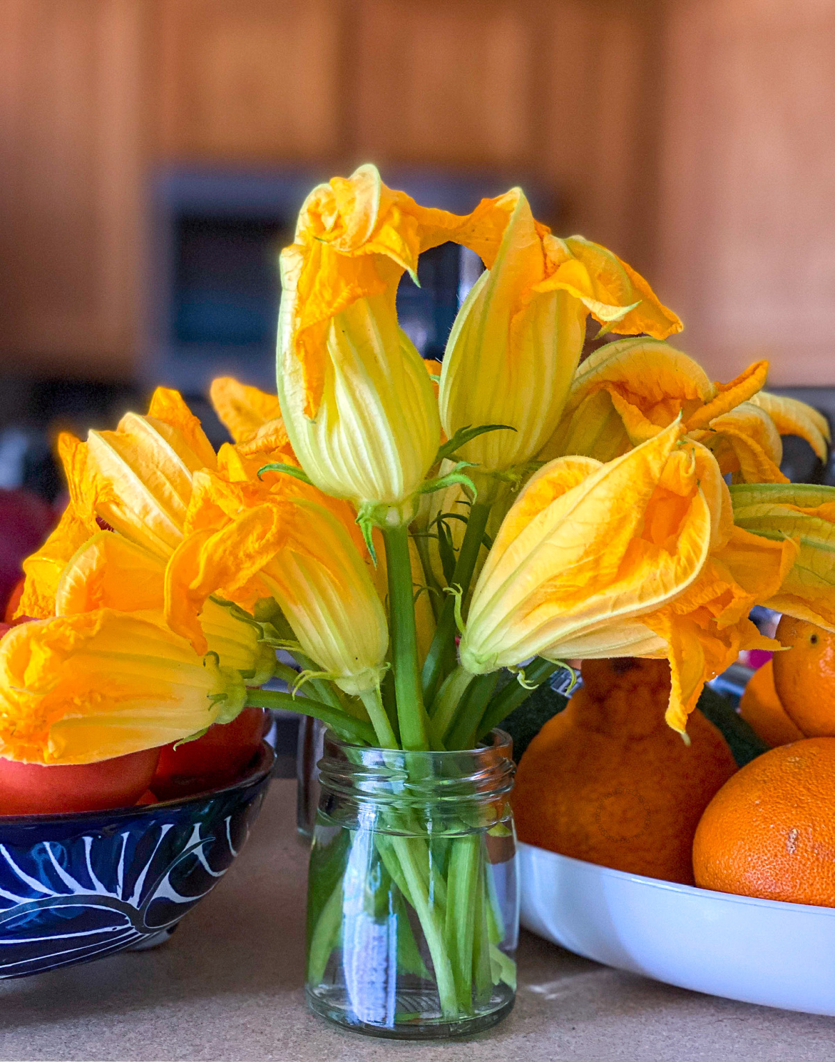 un vaso con flores de calabacín en agua